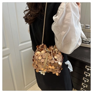 Detail of sequins bucket bag featuring pearl drawstring and gold metal chain strap