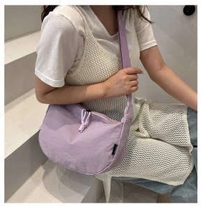 Detail van de lichtpaarse nylon halvemaanvormige tas met zwart label en geknoopte rits