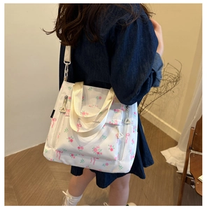 Detailed shot of white floral tote bag with pink roses and adjustable shoulder strap