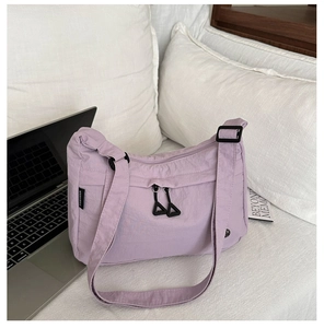 Dettaglio borsa in nylon viola con tasca a zip e tracolla in tessuto coordinato