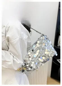 Detail shot of shimmering silver sequin shoulder bag with sleek strap on a model