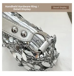 Macro detail of silver sequins texture and premium metal ring hardware on handbag