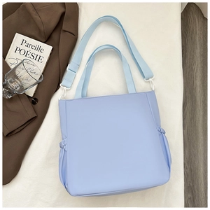 Detailed top view of light blue nylon tote bag with drawstring side pockets and dual straps