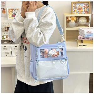 Detail of light blue nylon ita bag featuring double transparent windows and adjustable strap