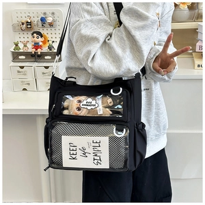 Detail of black ita bag featuring dual transparent windows for display and adjustable strap