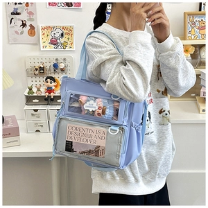 Detail of light blue ita bag showing dual clear windows with plush doll and card inserts