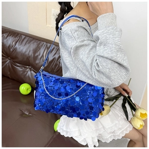 Detail of blue sequined handbag featuring a metallic chain and elegant shoulder strap