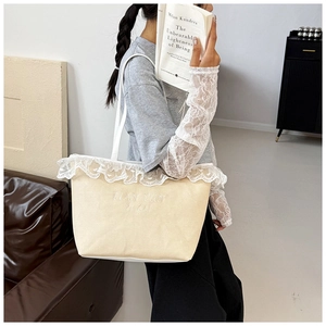 Détail du cabas en toile crème avec bordure en dentelle blanche et bandoulière