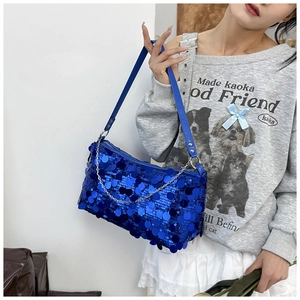Detail of royal blue sequin handbag featuring a metallic chain strap and shiny texture
