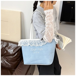 Detail of light blue tote bag with white lace trim and minimalist thin shoulder straps
