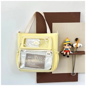 Detail view of yellow Ita Bag showing double transparent front pockets for decorations