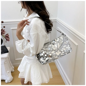 Silver sequin shoulder bag shown as a stylish accessory with a white casual outfit
