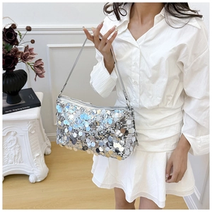 Detailed view of silver iridescent sequins on a stylish shoulder bag with metallic strap
