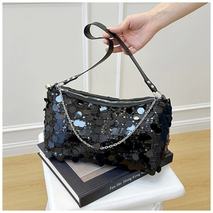 Detail of black sequined handbag with silver chain strap and zipper closure