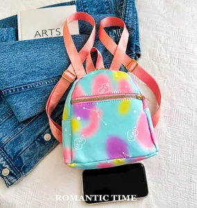 Detailed view of tie-dye nylon mini backpack with heart pattern and smartphone size comparison