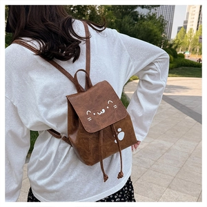 Vue de style de vie d'un mini sac à dos marron avec motifs de pattes de chat