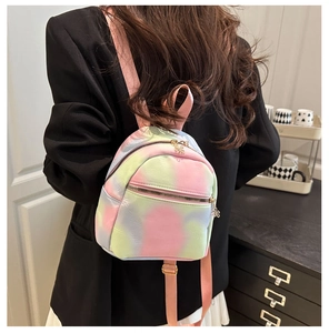 Back view of a mini tie-dye backpack in sweet pastel colors worn by a model