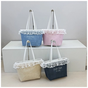 Détail de quatre sacs fourre-tout avec bordure en dentelle et lettrage brodé en plusieurs couleurs