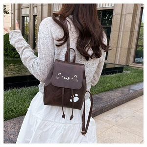 Sac à dos marron en cuir PU avec motif chat et cordon de serrage porté par un mannequin