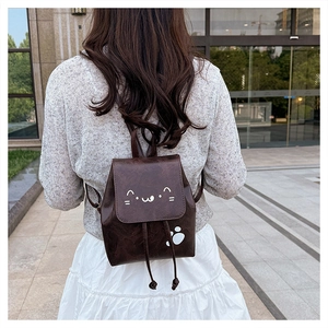 Détail d'un mini sac à dos en cuir PU marron avec chat porté par un mannequin en extérieur
