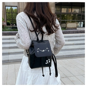 Vue détaillée du visage de chat mignon sur le sac à dos en cuir noir avec cordon de serrage