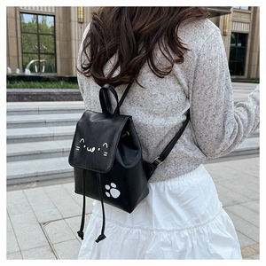 Détail d'un sac à dos en similicuir noir au motif chat avec fermeture à cordon