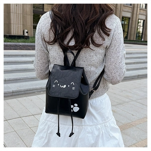 Close-up of black PU leather mini backpack with cute cat patterns and drawstring detail
