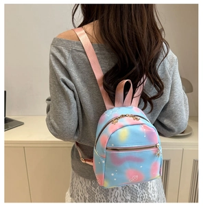 Detailed close-up of a mini backpack featuring pastel tie-dye colors and a golden heart zipper