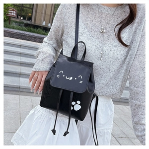 Détail d'un mini sac à dos en cuir PU noir avec un joli visage de chat blanc et patte