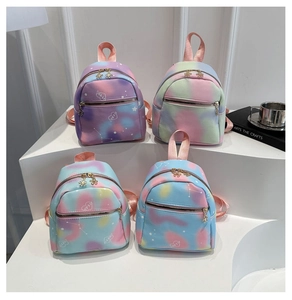 Detail of mini tie-dye backpacks in candy colors with heart patterns and flower zippers