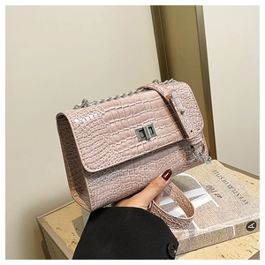 Detailed macro view of pink crocodile embossed leather and silver twist-lock closure