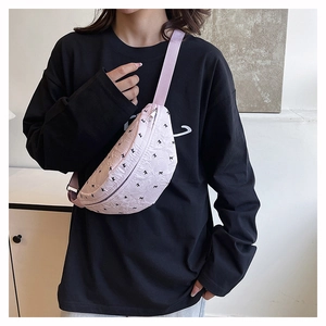 Detail of pink crossbody bag with black bow patterns and adjustable wide strap