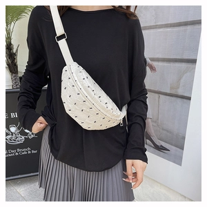 Close-up of quilted white fanny pack with black rabbit print and metal zipper details