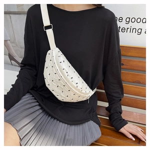 Detailed shot of white crescent crossbody bag with black animal embroidery and strap