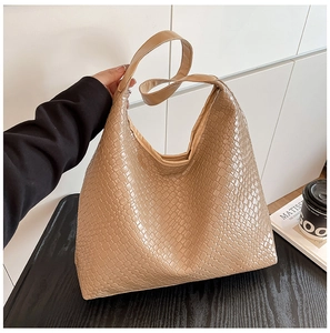 Detail of a large woven tote bag with a checkered leather texture and hobo style