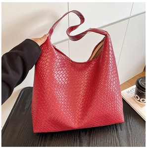 Macro detail of red woven leather tote bag featuring classic intricate texture design