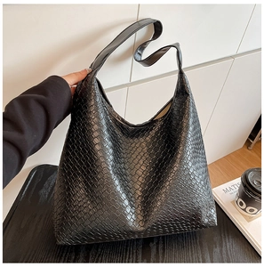Macro detail of black woven leather tote bag with vintage hobo style and large texture