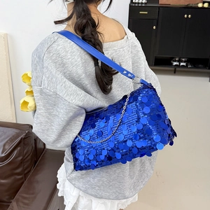 Chic bright blue sequined shoulder bag with silver chain strap shown in a home setting