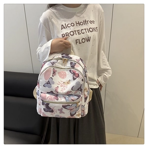 Detail of white nylon backpack with colorful butterfly print and gold zippers