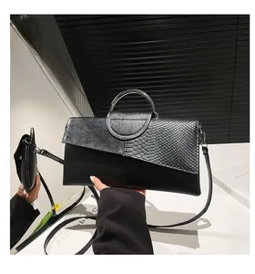 Dettaglio della pochette nera con motivo a serpente e manico tondo in metallo argento