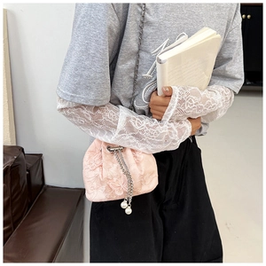 Detail of pink lace drawstring bucket bag with butterfly embroidery and pearl tassel