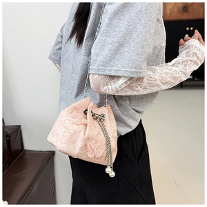 Detail of light pink lace bucket bag with butterfly embroidery and pearl drawstring