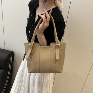 Chic khaki pebbled leather tote bag with gold hardware shown on female model