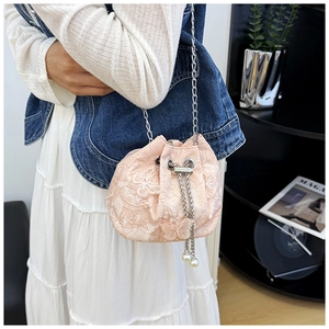 Detail of pink lace bucket bag with butterfly embroidery and pearl drawstring chain