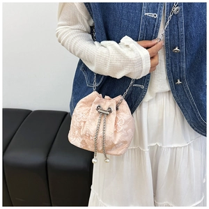 Detail of pink embroidered silk bucket bag with pearl pendant and silver chain strap