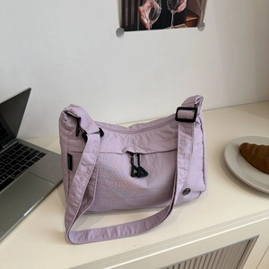 Detail view of lavender nylon tote bag with front zipper pocket and adjustable strap