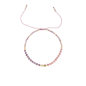 Detail of beaded bracelet showing purple gradient stones and golden accent beads