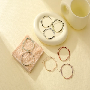 Adjustable Morse code bead bracelets in multiple colors on a textured aesthetic background