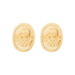Macro detail of gold oval earrings with embossed angel Cupid design and vintage texture