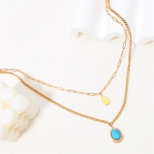 Double-layered gold stainless steel necklace featuring turquoise and smooth oval pendants